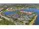 Expansive aerial view showcasing community amenities including tennis courts, clubhouse and a lake at 16055 Golden Lakes Dr, Wimauma, FL 33598
