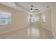 Bright bedroom featuring tile floors, multiple windows and a ceiling fan at 16055 Golden Lakes Dr, Wimauma, FL 33598