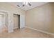 Open bedroom with a ceiling fan, closet, neutral walls, and tile flooring at 16055 Golden Lakes Dr, Wimauma, FL 33598