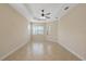 Spacious bedroom featuring a tray ceiling with fan and bright natural light from the large window at 16055 Golden Lakes Dr, Wimauma, FL 33598