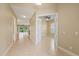 Bright hallway featuring neutral paint, tile flooring, and openings to other rooms at 16055 Golden Lakes Dr, Wimauma, FL 33598