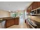 Open concept kitchen features stainless appliances, granite counters, and a view to the outdoor patio at 16055 Golden Lakes Dr, Wimauma, FL 33598