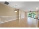Open concept living/dining room with large tile floors and view through screened lanai at 16055 Golden Lakes Dr, Wimauma, FL 33598