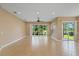 Bright, open living room featuring tiled floors and sliding glass doors leading to the outdoor space at 16055 Golden Lakes Dr, Wimauma, FL 33598