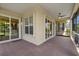Beautiful brick patio with ceiling fan and screened in porch has sliding glass doors to the interior at 16055 Golden Lakes Dr, Wimauma, FL 33598