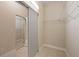 Walk-in closet featuring mirror sliding door, ample shelving and storage space in the home at 16055 Golden Lakes Dr, Wimauma, FL 33598
