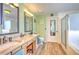 Bathroom featuring double sinks, granite counters, and shower with glass door at 1624 Maximilian Dr, Wesley Chapel, FL 33543