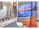 Charming bathroom featuring a Mickey Mouse themed shower curtain, a coordinated vanity and sink, and ample lighting at 1624 Maximilian Dr, Wesley Chapel, FL 33543