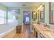 Bathroom featuring dual sinks, granite counters, and soaking tub at 1624 Maximilian Dr, Wesley Chapel, FL 33543