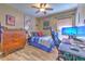 Functional bedroom space featuring tile floors, a modern desk setup, and comfortable furnishings, ideal for work and relaxation at 1624 Maximilian Dr, Wesley Chapel, FL 33543