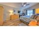 Well-lit bedroom featuring wood-look floors, ceiling fan, and neutral paint at 1624 Maximilian Dr, Wesley Chapel, FL 33543