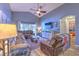 Well-lit living room with tile floors, comfortable seating, a ceiling fan, and a sliding glass door at 1624 Maximilian Dr, Wesley Chapel, FL 33543