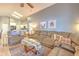 Spacious living room featuring tile floors, a large sofa, and seamlessly connected to a modern, open-concept kitchen at 1624 Maximilian Dr, Wesley Chapel, FL 33543