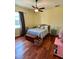 Comfortable bedroom featuring hardwood floors, a ceiling fan, and natural light at 17127 Brown Rd, Odessa, FL 33556