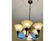Close-up of a chandelier featuring tan shades and dark bronze hardware at 17127 Brown Rd, Odessa, FL 33556