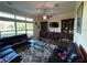 Spacious living room featuring large windows, a ceiling fan, a dark leather sofa and a built-in display case at 17127 Brown Rd, Odessa, FL 33556