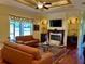 Cozy living room featuring a fireplace and a large window with natural light at 17127 Brown Rd, Odessa, FL 33556