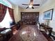 Spacious office area featuring a large patterned rug, dark hardwood floors, and a display cabinet at 17127 Brown Rd, Odessa, FL 33556