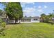 Spacious backyard with lush green grass and mature trees, offering ample space for outdoor activities at 1751 Ashton Abbey Rd, Clearwater, FL 33755