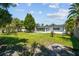 Spacious backyard with mature trees, green grass, and a partially shaded area, perfect for outdoor activities at 1751 Ashton Abbey Rd, Clearwater, FL 33755