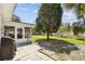 Spacious backyard featuring a patio area, mature trees, and lush green grass at 1751 Ashton Abbey Rd, Clearwater, FL 33755