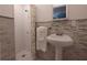 Charming bathroom showcasing a tiled shower with glass doors and a pedestal sink with stylish fixtures at 1751 Ashton Abbey Rd, Clearwater, FL 33755
