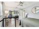Light-filled bedroom featuring mirrored closet, window, ceiling fan, and a treadmill at 1751 Ashton Abbey Rd, Clearwater, FL 33755