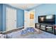 Light blue bedroom featuring a comfortable bed, television, and storage, creating a peaceful retreat at 1751 Ashton Abbey Rd, Clearwater, FL 33755