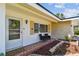 Inviting front porch with seating area, decorative wreath on door, and lush landscaping for a welcoming curb appeal at 1751 Ashton Abbey Rd, Clearwater, FL 33755