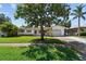 Charming single-story home with a well-manicured lawn and mature landscaping, including a large shade tree at 1751 Ashton Abbey Rd, Clearwater, FL 33755