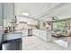Open concept kitchen with white cabinets, tiled backsplash, and stainless appliances at 1751 Ashton Abbey Rd, Clearwater, FL 33755
