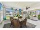 Bright sunroom with a ceiling fan and table creating a comfortable space for relaxation at 1751 Ashton Abbey Rd, Clearwater, FL 33755