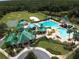 Aerial view of the community pool, clubhouse, baseball and sports courts, and pond at 19116 Nature Palm Ln, Tampa, FL 33647