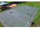 Overhead view of an outdoor basketball court and playground that feature hoops and play structures in lush green common area at 19116 Nature Palm Ln, Tampa, FL 33647