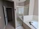 Bright bathroom featuring a soaking tub, glass-enclosed shower, and neutral tile at 19116 Nature Palm Ln, Tampa, FL 33647