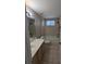 Bathroom with a tiled shower/tub, large vanity, and window at 19116 Nature Palm Ln, Tampa, FL 33647