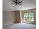Spacious carpeted bedroom with a ceiling fan and large window view at 19116 Nature Palm Ln, Tampa, FL 33647