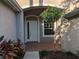 Front porch with brick flooring, a white front door, and a window showcasing a charming and welcoming entrance at 19116 Nature Palm Ln, Tampa, FL 33647