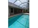 Sparkling pool under a screened enclosure, complete with a spacious patio for leisure and outdoor enjoyment at 19116 Nature Palm Ln, Tampa, FL 33647