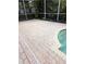 Brick pool deck with access to the refreshing blue pool and tropical garden in background at 19116 Nature Palm Ln, Tampa, FL 33647