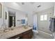 Bathroom with a marble countertop, large mirror, and a shower and tub combo at 19254 Blount Rd, Lutz, FL 33558