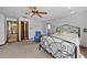 Bedroom with a queen bed, ceiling fan, and convenient access to a walk-in closet at 19254 Blount Rd, Lutz, FL 33558