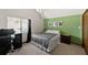 Cozy bedroom with a green accent wall, plush carpeting, and a comfortable bed at 19254 Blount Rd, Lutz, FL 33558