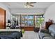 Spacious bedroom with lake view featuring a ceiling fan, tile flooring, and large windows at 19254 Blount Rd, Lutz, FL 33558