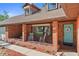 Charming brick home featuring a cozy front porch with rocking chairs and a welcoming blue front door with decorative wreath at 19254 Blount Rd, Lutz, FL 33558