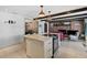 Open kitchen with island cooktop, and connected living area, features brick fireplace and rustic wood beam ceiling at 19254 Blount Rd, Lutz, FL 33558
