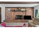Living room with brick fireplace, mantle and decor, with mounted television for entertainment at 19254 Blount Rd, Lutz, FL 33558