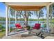 Covered patio with comfortable seating, a fire pit, and scenic lake views at 19254 Blount Rd, Lutz, FL 33558