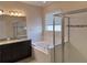 Bathroom featuring a soaking tub, tiled shower, and dark vanity with granite countertop at 19514 Sea Myrtle Way, Tampa, FL 33647