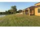 Exterior view shows screened-in patio with pond views and home with lush landscaping at 19514 Sea Myrtle Way, Tampa, FL 33647